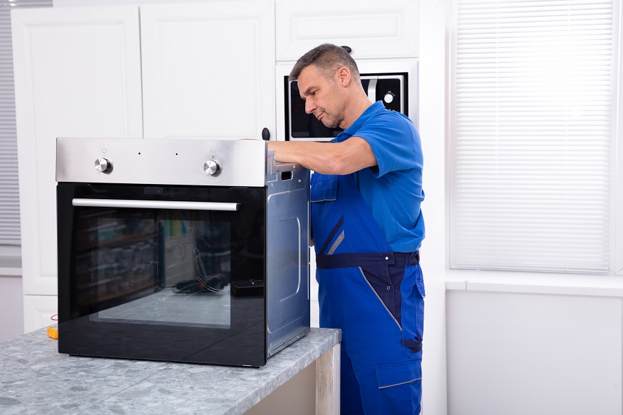 Oven technician repairing oven on kitchen worktop Perth Oven technician repairing oven on kitchen worktop Perth